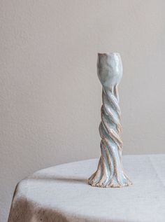 a white vase sitting on top of a table