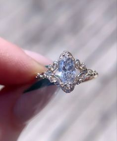 someone is holding an engagement ring with a fancy design on the front and center stone