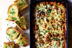 a casserole dish with bread slices and parmesan cheese on the side