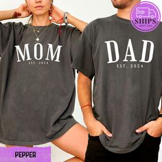 a man and woman wearing matching t - shirts with the words mom and dad printed on them