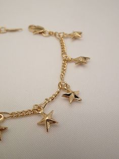 The stars lined up when this beauty was created! The Star Bracelet is one superstar! This star charm bracelet features an infinity dainty bracelet adorned with tiny puff star charms. Best of all, she comes in anklet form too! Your sure to stir a sensation with this cutie! Knock this look out of this galaxy with these must have star jewelry pieces too! - The Star Choker Necklace - The Starburst Earrings - The Moon and Star Necklace Available in 24K gold or rhodium plating over steel Size: 7" (we Adjustable Gold Star Chain Bracelet, Adjustable Gold Chain Bracelet With Star Charm, Adjustable Gold Star-shaped Chain Bracelet, Dainty Star Charm Bracelet, Adjustable Gold Star Charm Bracelet, Gold Star Charm Bracelet, Gold Anklet With Star Charm As Gift, Gold Anklets With Star Charm For Gift, Gold Star Charm Chain Bracelet