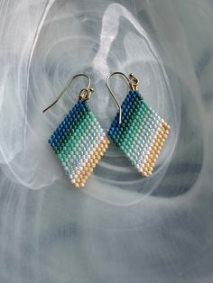 Dreaming of summer with these hand woven beaded earrings in beachy colors.  Earrings are light weight made with Japanese Miyuki Delica beads woven by hand attached to 14k gold plated earring hooks. Multicolor Woven Earrings For Beach, Multicolor Woven Beach Earrings, Beach Multicolor Woven Earrings, Handwoven Beaded Earrings For Beach In Summer, Handwoven Beaded Earrings For Summer Beach, Blue Woven Jewelry For Summer, Handmade Beaded Earrings With Round Beads For Beach, Handmade Round Beads Beaded Earrings For Beach, Handmade Green Beaded Earrings For Vacation