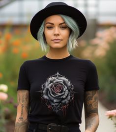 Black Rose Shirt, Black Rose Flower t shirt, Gothic Rose Shirt, Black Rose T-shirt, Halloween Black Rose Shirt This classic unisex jersey short sleeve tee fits like a well-loved favorite. Soft cotton and quality print make users fall in love with it over and over again. These t-shirts have-ribbed knit collars to bolster shaping. The shoulders have taping for better fit over time. Dual side seams hold the garment's shape for longer.  .: 100% Airlume combed and ringspun cotton (fiber content may vary for different colors) .: Light fabric (4.2 oz/yd² (142 g/m .: Retail fit .: Tear away label .: Runs true to size Black Short Sleeve T-shirt With Rose Print, Black Rose Print Short Sleeve T-shirt, Black Crew Neck T-shirt With Rose Print, Rose Print Crew Neck Top For Streetwear, Dead Rose, Flower T Shirt, Black Rose Flower, Gothic Rose, Rose Shirts