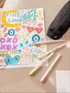 some markers and pencils are sitting on a table next to an art project bag