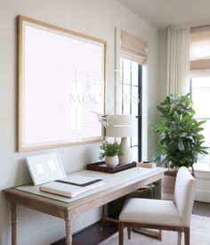 a desk with a laptop computer on top of it next to a chair and potted plant