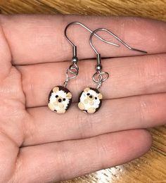 a pair of earrings that have been made to look like a teddy bear on them