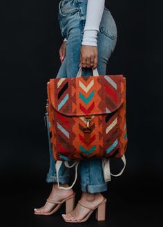 Orange with teal, brown, lilac, cream and black Aztec inspired backpack Clasp closure on the front Adjustable straps and handle Measures 14" x 11.5" x 4.5" 100% Cotton Lining: 100% Polyester Backpack Styling, Painted Backpack, Bag Shapes, Painting Backpack, Pictures Friends, Fancy Hands, Orange Backpacks, Vintage Native American Jewelry, Colorful Handbags