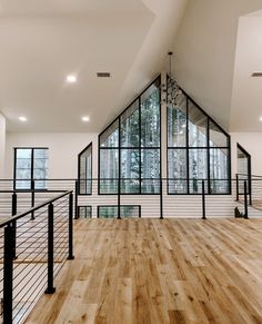 an empty room with wood flooring and metal railings in the middle of it