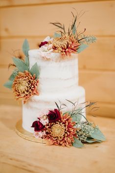 a three tiered white cake with flowers on top