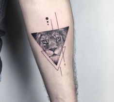 a man's arm with a lion and triangle tattoo on it