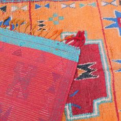 two colorful rugs laying on top of each other