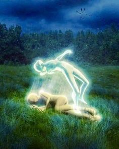 a person laying in the grass with a light painting on their back