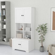 a bathroom with a white cabinet next to a potted plant