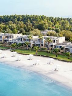 an aerial view of a beach resort with lawn chairs and umbrellas