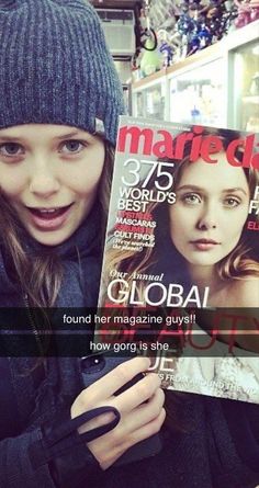 a woman holding up a magazine in front of her face