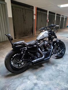 a black motorcycle parked in an empty parking garage with no one on it's bike