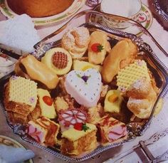 a platter filled with lots of different types of desserts on top of a table