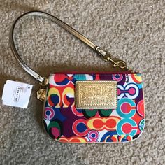 Coach Pop C Multi Color Signature Wrislet Wallet F48151 Special Features: Bright Gold Lurex/Metallic Leather Piping, Trim & Wrist Strap. Strap Measures 14" From End To End With A Brass Dog Leash / Spring Clip At One End. The Multi-Color Poppy Pop C Signature Denier Nylon Fabric Is Beautiful! Coach & Poppy Embossed Rectangular Logo Sewn On Front. * Imported From : Usa * Exterior: The Multi-Color Poppy Pop C Signature Denier Nylon Fabric Is Beautiful! Coach & Poppy Embossed Rectangular Logo Sewn Multicolor Clutch With Phone Pocket, Compact Multicolor Travel Bags, Multicolor Compact Everyday Bag, Trendy Coach Rectangular Clutch, Trendy Rectangular Coach Clutch, Trendy Multicolor Clutch Wallet, Multicolor Coach Clutch Bag, Coach Multicolor Clutch Bag, Multicolor Coach Bags As Gifts