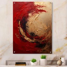 an abstract painting in gold and red on a white wall above a fireplace mantel