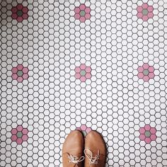 a pair of brown shoes sitting on top of a tiled floor next to a wall