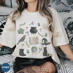 Introducing our Witchy Cottagecore Shirt - the perfect choice to express yourself this spooky season! This witchy aesthetic tshirt features a watercolor witchcraft collage graphic making it the perfect way to show off your unique style. Whether you're looking for a dark cottagecore shirt for yourself or for someone special, you'll find it here. Get ready to show off your love for the witchcore aesthetic with this trendy tee! Comfort Colors introduces its garment-dyed t-shirt made 100% with ring- Witchy Tshirt Design, Fall Goblincore Short Sleeve Tops, Halloween Fairy Grunge Tops, Goblincore Cotton Crew Neck Top, Halloween Fairy Grunge Cotton T-shirt, Fairy Grunge Halloween T-shirt With Crew Neck, Halloween Fairy Grunge T-shirt With Crew Neck, Fairy Grunge Halloween Crew Neck Top, Fairy Grunge Cotton T-shirt For Halloween