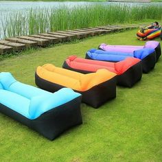 an inflatable lounge chair sitting on the grass next to a body of water