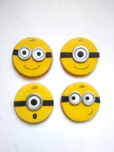 four yellow and black buttons with eyes on each one in the shape of a minion