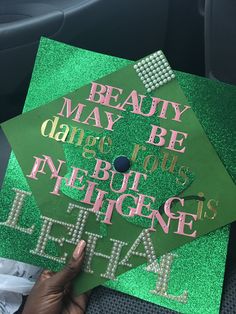 someone is holding up a green graduation cap