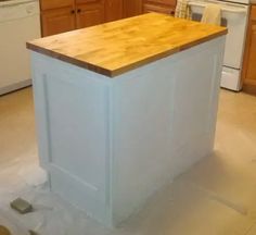 a kitchen island with a butcher block top on the floor in front of an oven