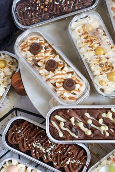 there are many different desserts in plastic containers on the table, including ice cream and chocolate