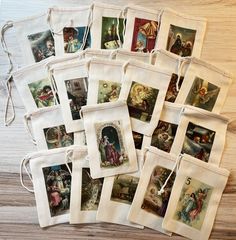 a bunch of pictures hanging from strings on a wooden table next to a bag filled with them