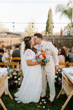 a bride and groom kissing in front of an outdoor ceremony