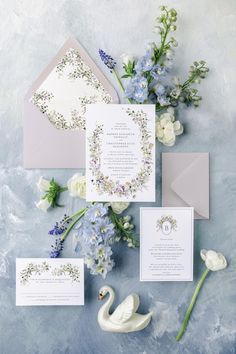 the wedding stationery is laid out with flowers and an envelope