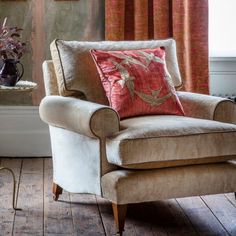 a chair with a pillow on it in front of a window