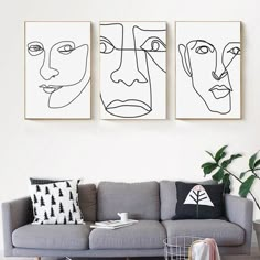 three black and white paintings on the wall above a couch