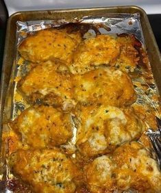 a pan filled with chicken and cheese covered in sauce