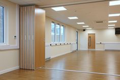 an empty room with hard wood floors and white trim on the doors, windows, and radiators