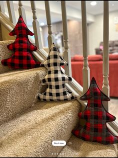 three christmas trees are sitting on the stairs