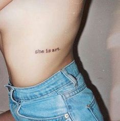 a person with a small tattoo on their stomach and the words, she isn't