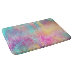 a colorful bath mat with watercolor paint on the bottom and sides, sitting on top of a white surface