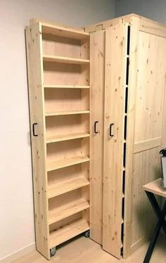 a large wooden cabinet sitting in the corner of a room next to a small table