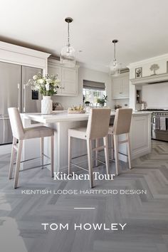 a kitchen with white cabinets and wooden floors is pictured in this image, there are four chairs at the center of the table