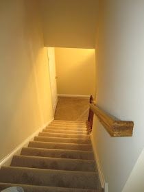 an empty hallway with stairs leading up to the door