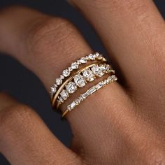 a woman's hand with three different rings on her finger and the ring is gold