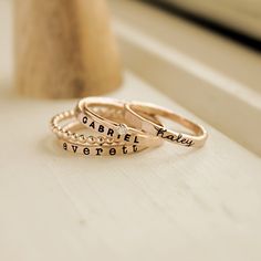 Mother's Day Gift | Personalized stackable ring set, engraved with a name, date, or special word.  Metal: 14k gold filled or fine/sterling silver Dimensions: 2mm tall on average, but our rings are handmade so variations will occur. The birthstone is 2mm on a 1mm band, and the beaded ring is 2 mm. Font: lowercase cursive, uppercase bold block, and lowercase typewriter Unsure what size you need? We highly recommend using our ring sizer for an accurate fit. Some people find that sizing up when stac Mother’s Ring Stackable, Adjustable Engraved Rings For Mother's Day, Adjustable Wedding Rings With Names, Rose Gold Rings With Names For Promise, Adjustable Rose Gold Engraved Ring, Adjustable Engraved Ring For Personalized Gift, Personalized Adjustable 14k Gold Stackable Rings, Gold Stackable Adjustable Rings With Engraving Option, Customizable Adjustable Yellow Gold Rings