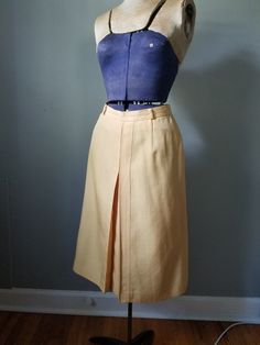 "Vintage 90s yellow pencil skirt with back clasp and zipper closure. Front has a pretty geomentric pleat. No obvious flaws or imperfections. Unsure of maker as there are no tags.  Built in slip. Flat measurements are as follows: Waist: 12.5\" Hip: 18\" Waist to Hem:  26\"" Fitted Pleated Pencil Skirt For Summer, Fitted Yellow Pencil Skirt For Spring, Yellow Pencil Skirt For Workwear, Yellow Knee-length Pencil Skirt For Spring, Elegant Yellow Pleated Bottoms, Fitted Yellow Lined Pleated Skirt, Fitted Yellow Pleated Lined Skirt, Yellow Midi Skirt For Work, Vintage Fitted Pleated Skirt For Work