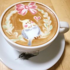 a cappuccino with an image of a cat on the side and flowers painted on it