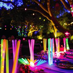 the table is set up with colorful lights and candles for an outdoor dinner or party