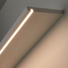 the corner of a room with a light coming from it's ceiling and some lights on