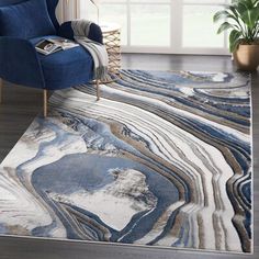 a blue chair sitting on top of a rug in a living room next to a window